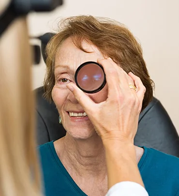 Person holding a trial lens during vision testing
