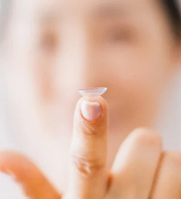 Contact lens balanced on a fingertip